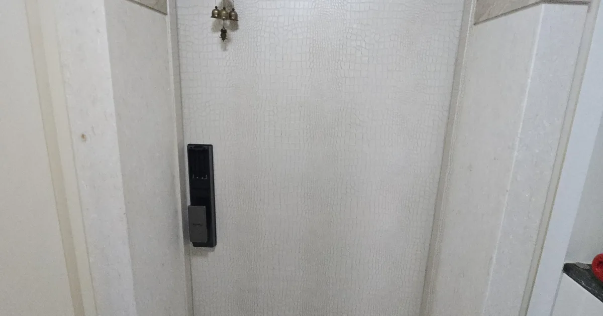 강남 아파트 현관문 힌지 부위를 점검하는 시공 현장 사진